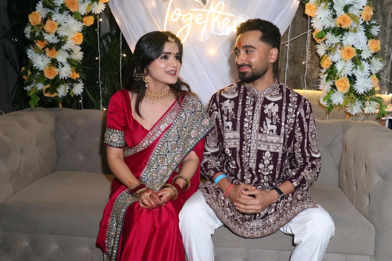 Dewanshu and Saumya seated together under a Together sign